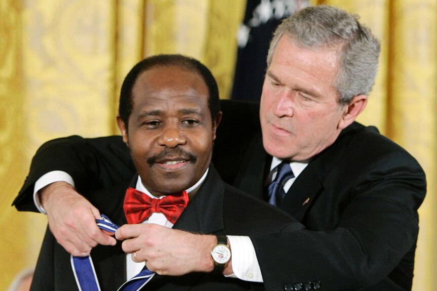 Paul Rusesabagina (left) is presented the Presidential Medal of Freedom by then-US president George W Bush.