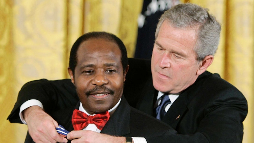 Paul Rusesabagina (left) is presented the Presidential Medal of Freedom by then-US president George W Bush.