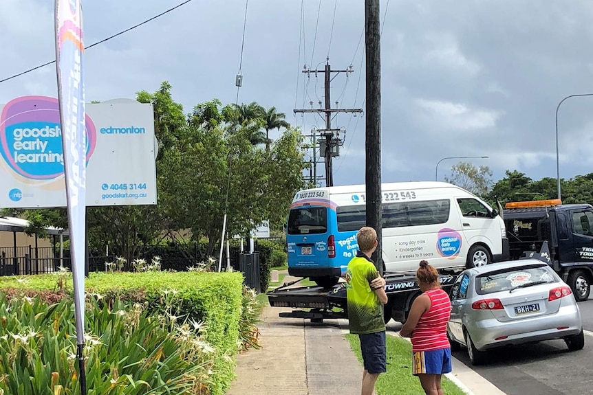 A minibus on a flatbed tow truck.