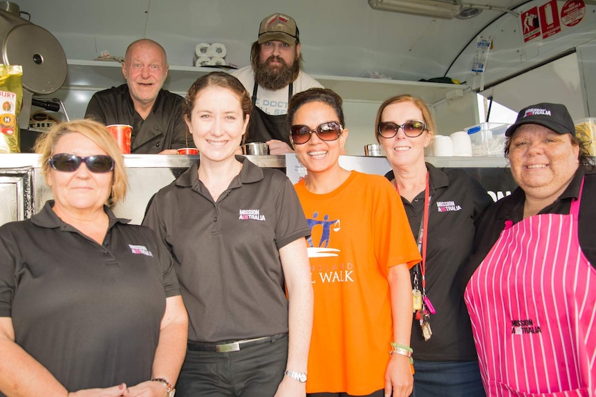Mission Australia staff and clients gather around the Cafe One van in Cairns.