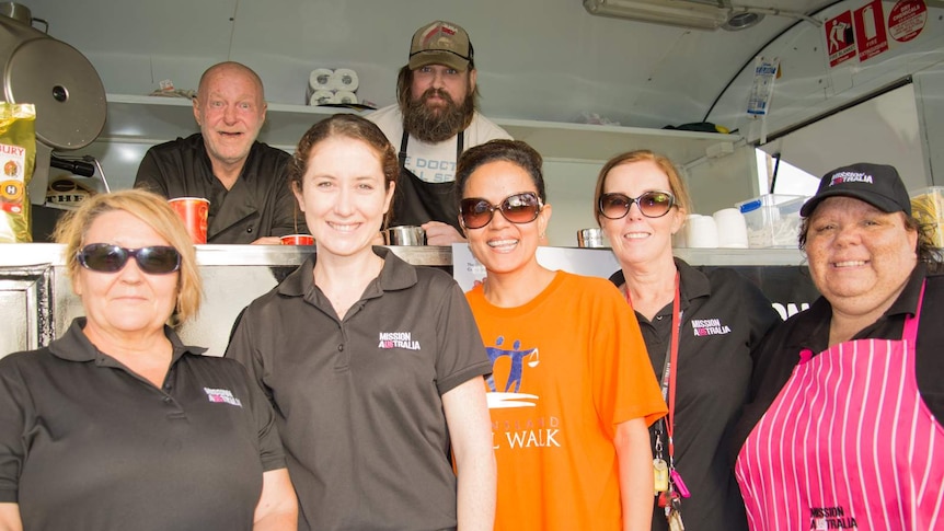 Mission Australia staff and clients gather around the Cafe One van in Cairns.