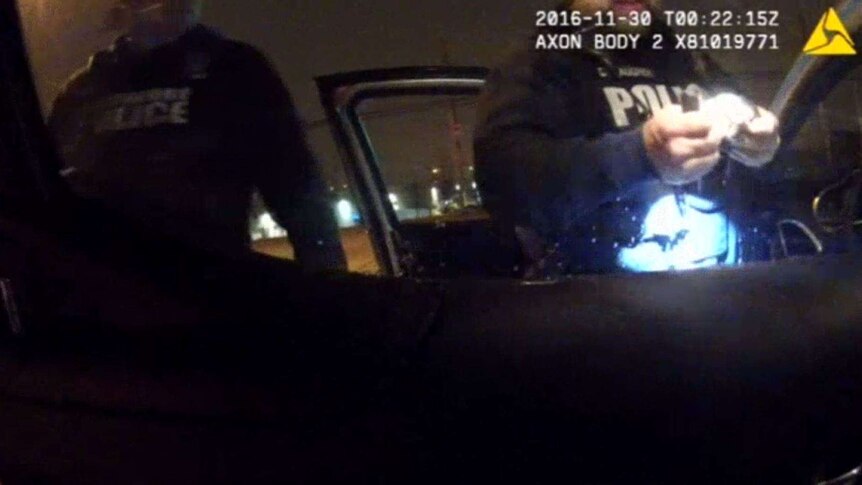 A video still of Baltimore police finding drugs in a car