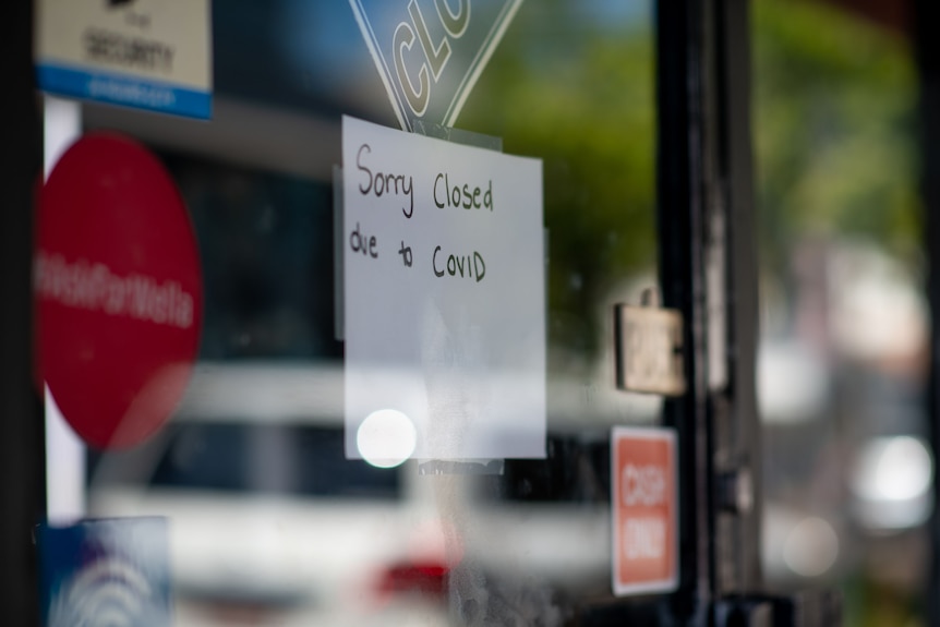 A photo of a sign on a shopfront saying: "Sorry, closed due to COVID".