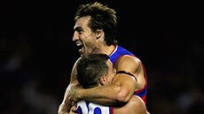 Matthew Robbins hoists up Scott West after his goal for the Bulldogs