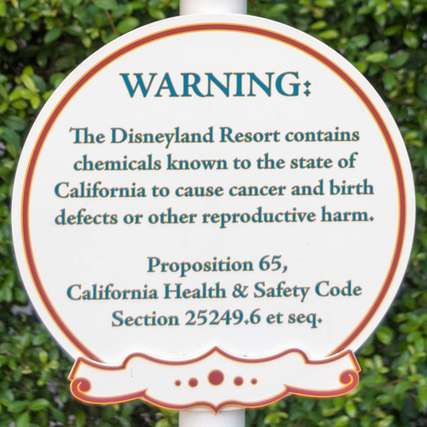 A circular sign saying "WARNING: The Disneyland Resort contains chemicals known to the state of California to cause cancer."