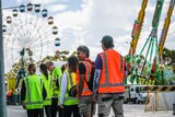 Group of workers in high vis outfits near festival rides