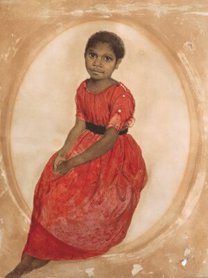 A portrait of a young Aboriginal girl with short hair wearing a bright red dress. She sits with her hands clasped in her lap