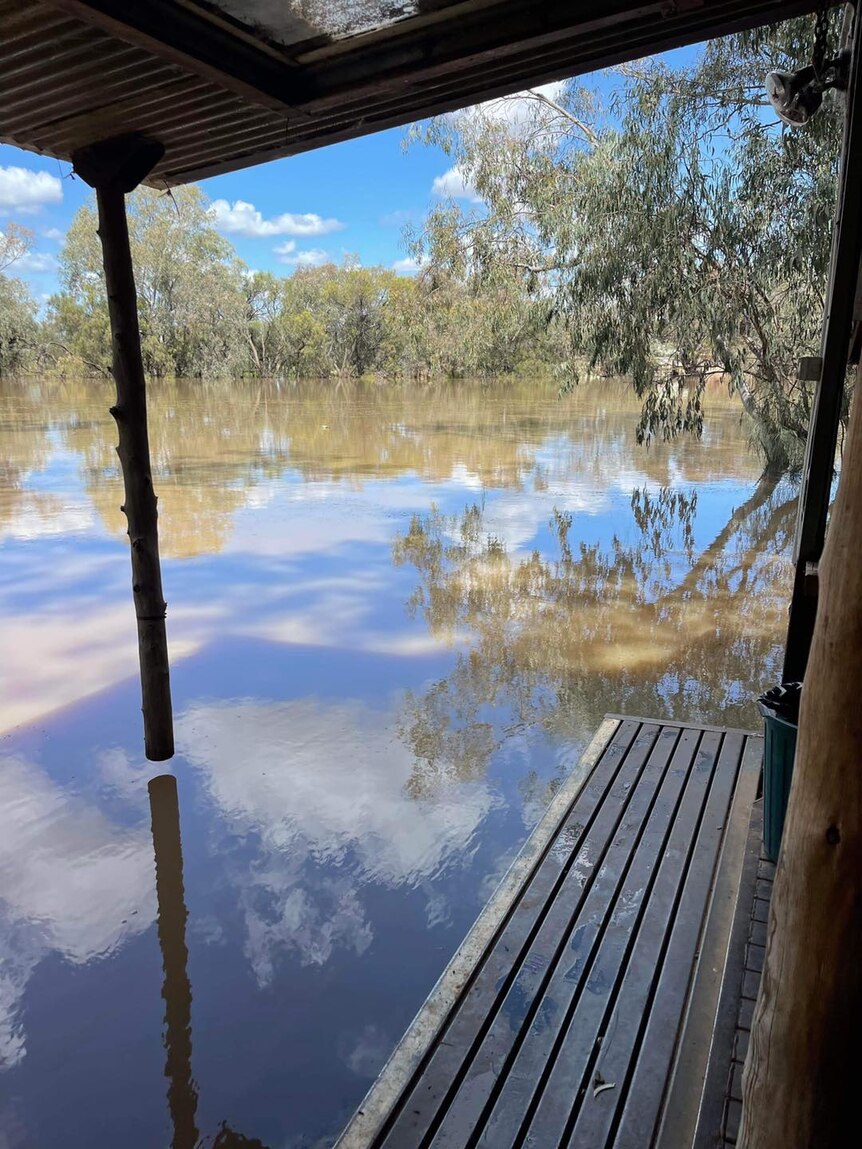 Floodwater comes up to balcony of a caravan park room