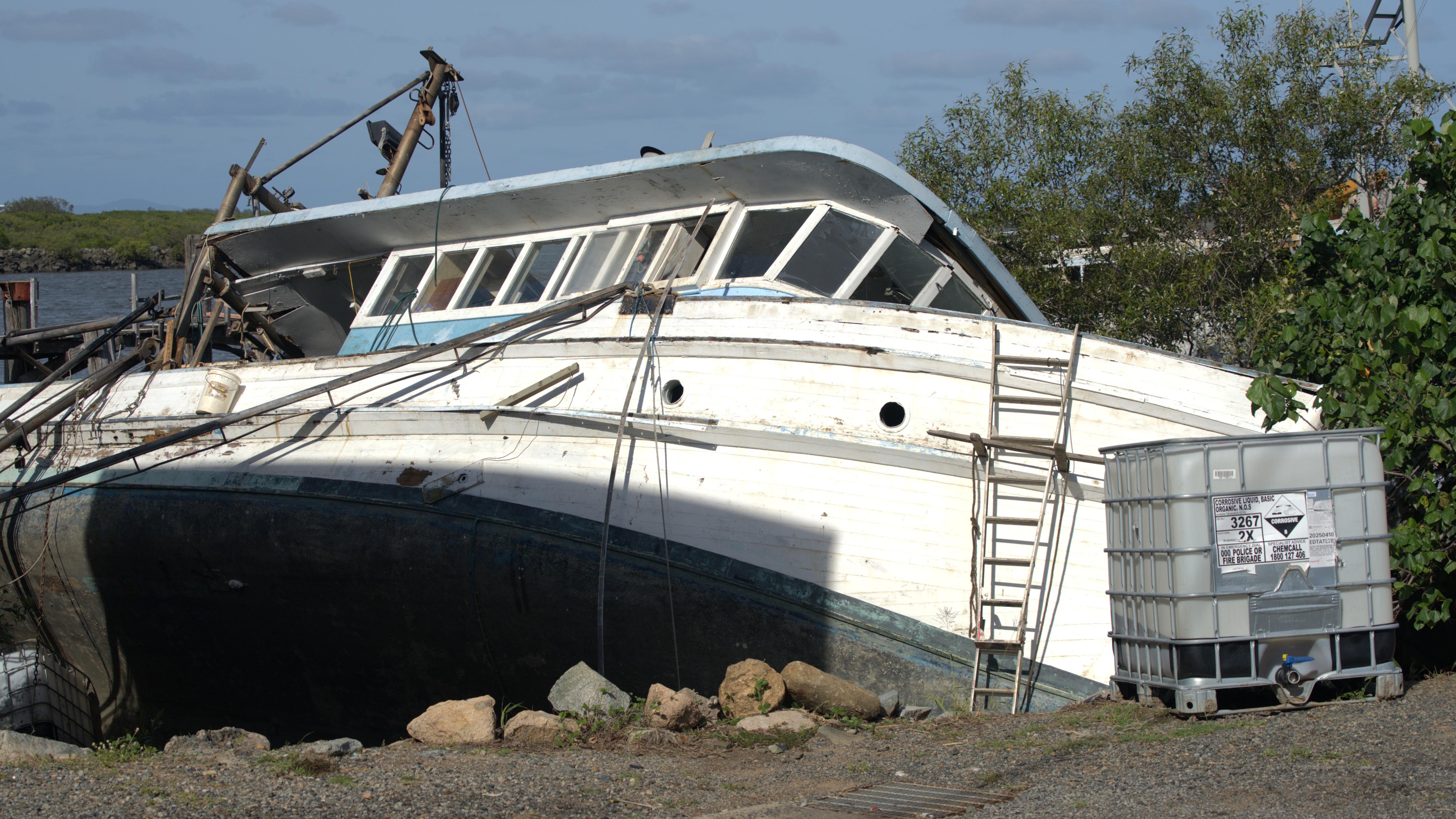 Un viejo barco apoyado sobre su costado en un río.