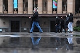 People wearing face masks walking through King George Square during COVID-19 lockdown in Brisbane.