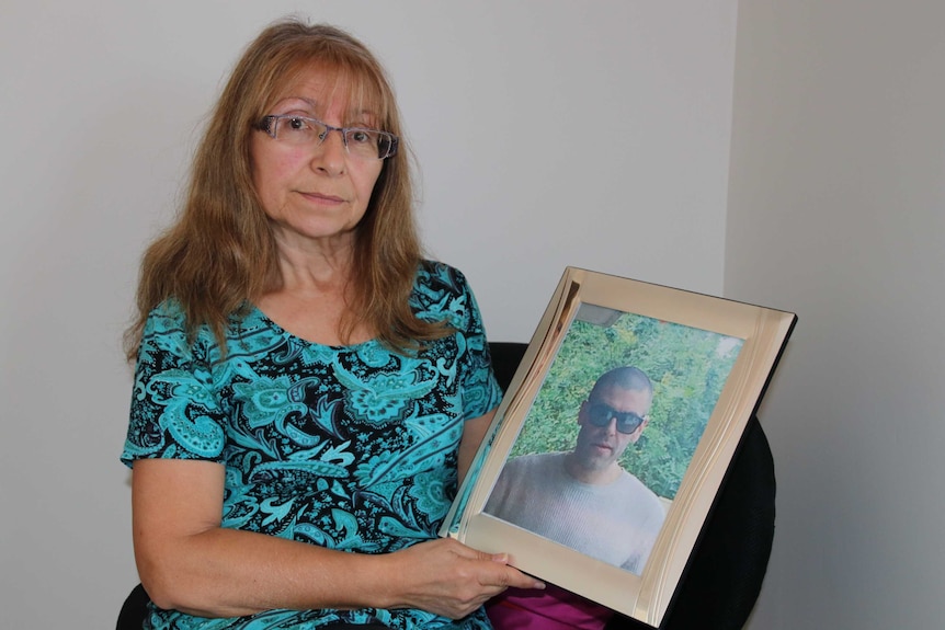 Angela Broadley holding a photo of her missing son Joseph Da Silva.