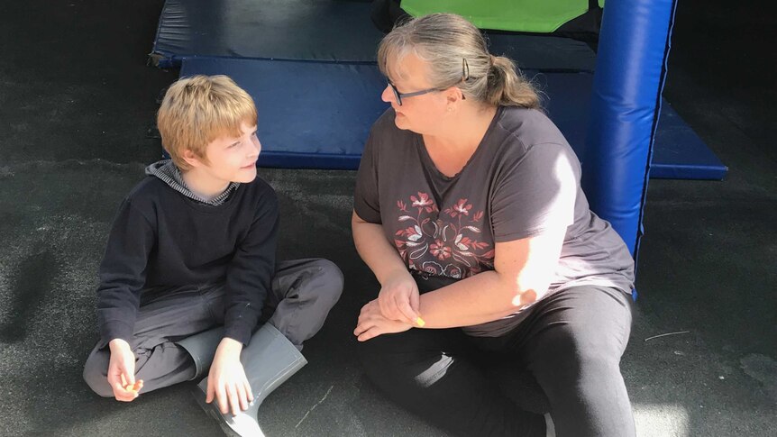 Martina McNeill smiles with son Alex sitting near a playground.