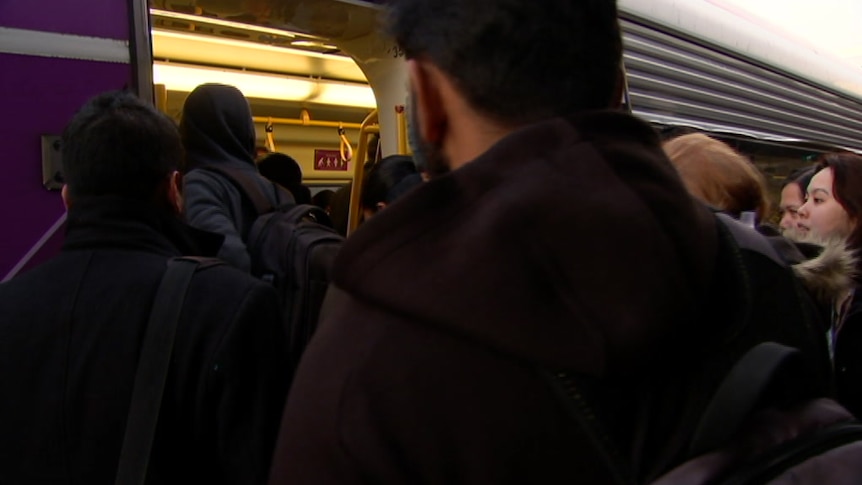 Commuters crowd through the doors of a train in Wyndham, Melbourne.