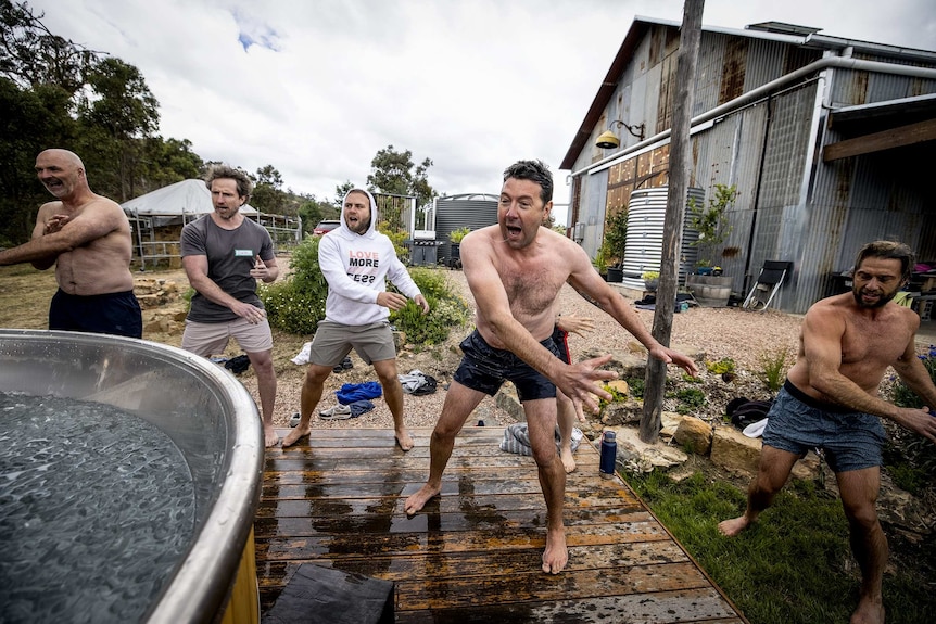 Men with legs apart move arms around their bodies