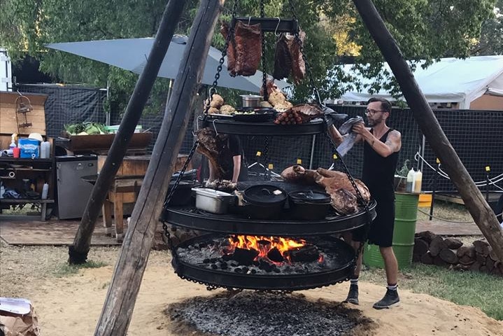 A man manoeuvres food at an eatery at the Garden of Unearthly Delights in Adelaide