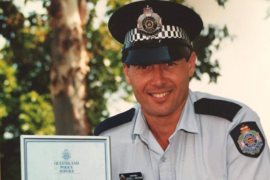 A police officer poses with a certificate