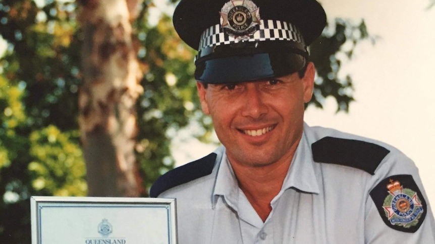 A police officer poses with a certificate
