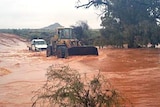 A dozer makes its way through floodwaters at Broken Hill.