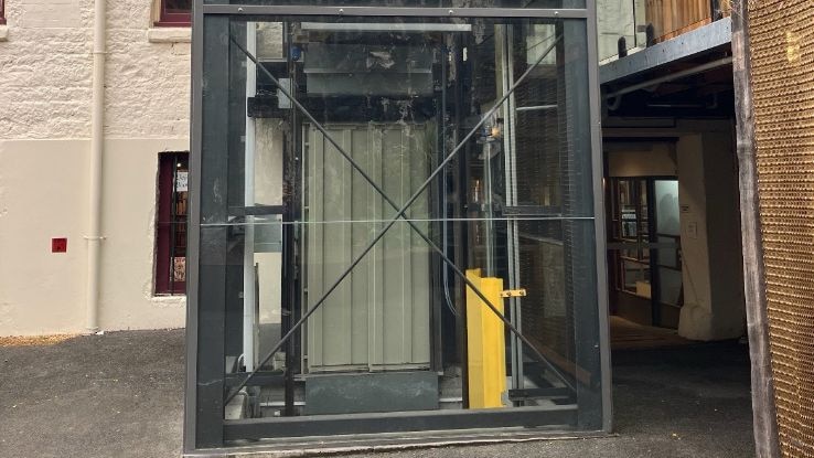 A lift inside a glass casing outside a building