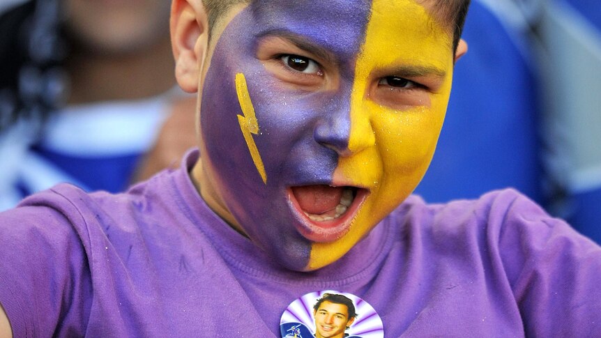 A young Melbourne Storm fan waits for the start of the NRL grand final.