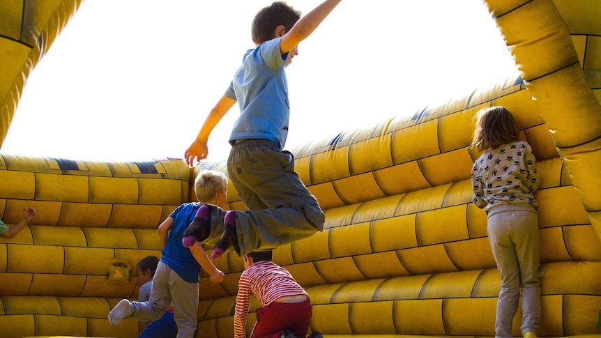 Boys jumping on jumping castle for a story about how to survive children's parties