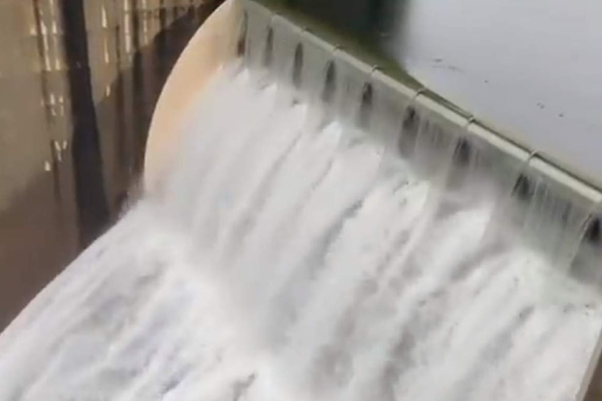water spilling over dam walls