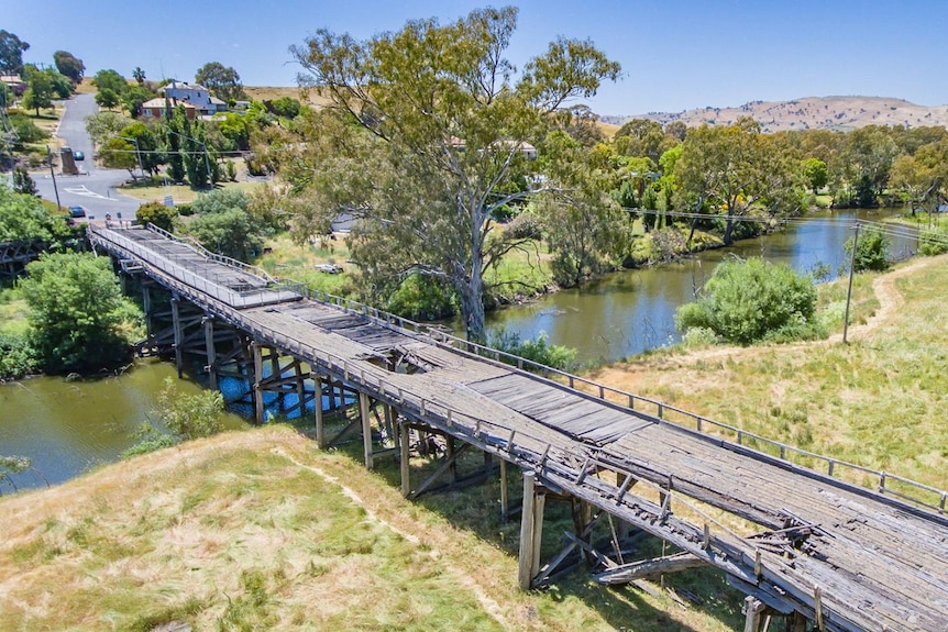 A long timber bridge with bits missing.