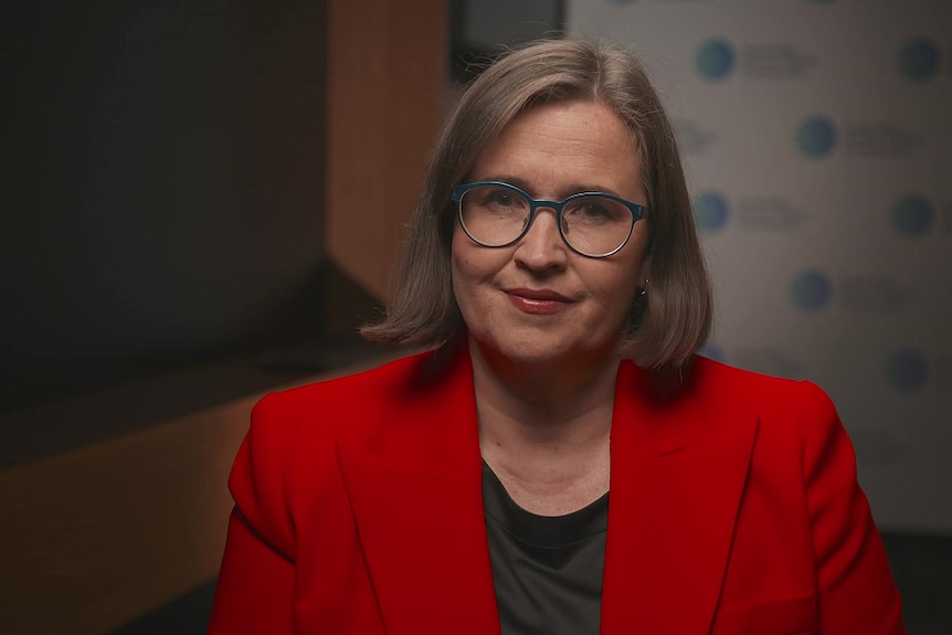 A woman wearing glasses and a red jacket