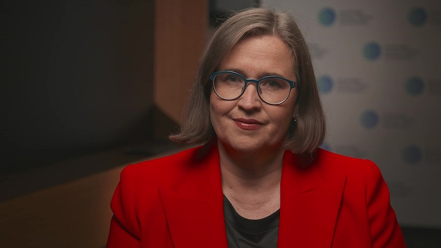 A woman wearing glasses and a red jacket