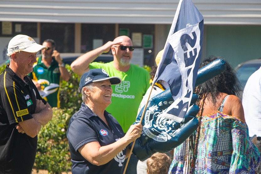 a woman wearing a hat and holding a flag