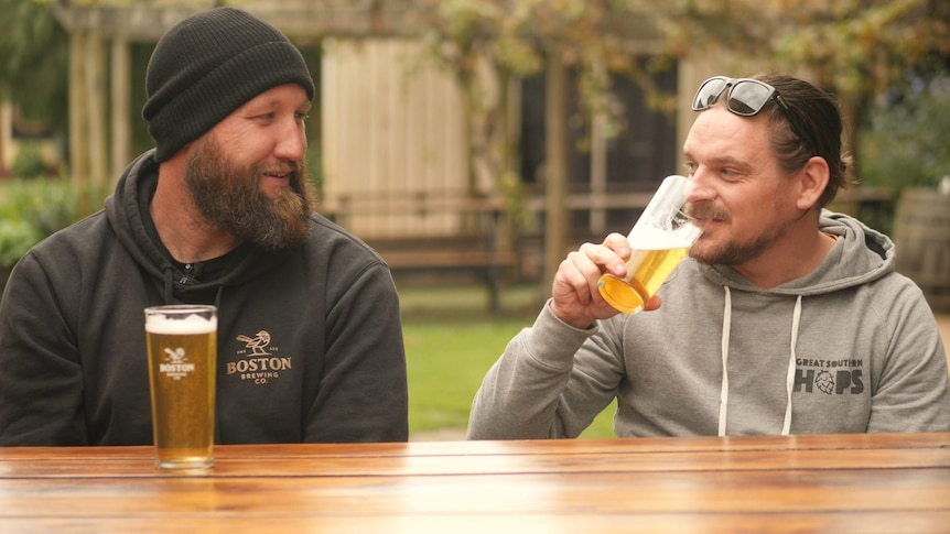 deux hommes rient et boivent de la bière