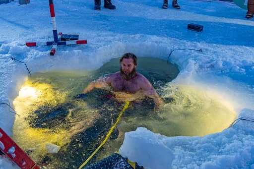 David Know swims in a whole in the Antarctic ice