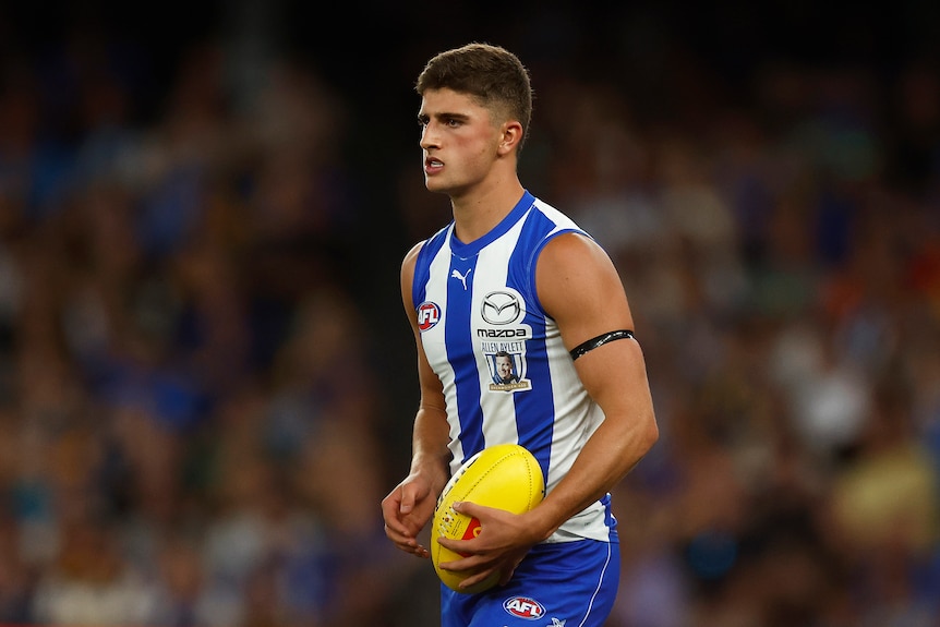 Harry Sheezel looks ahead while holding the ball