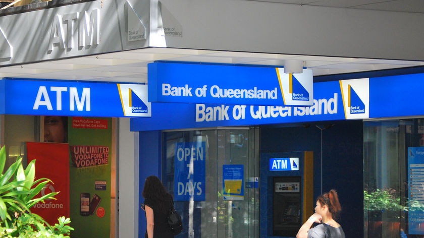 People walk past Bank of Queensland signs in Brisbane's CBD in March 2010.