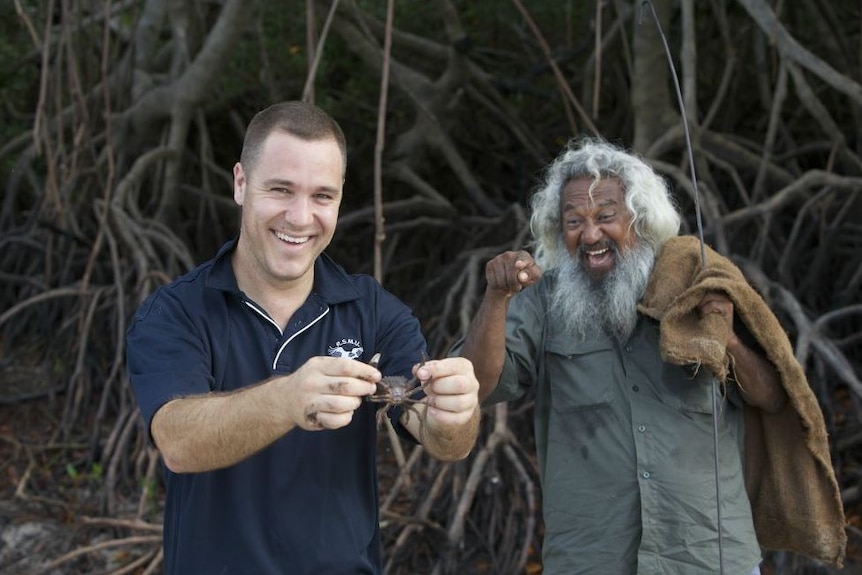 A photo of Brian Lee with a man holding a crab