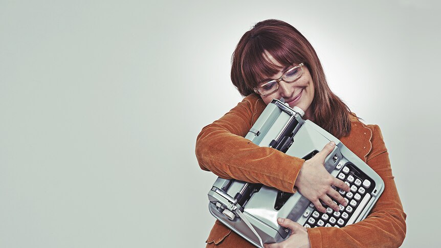 A woman hugging a typewriter.