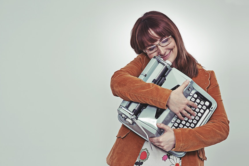 A woman hugging a typewriter.