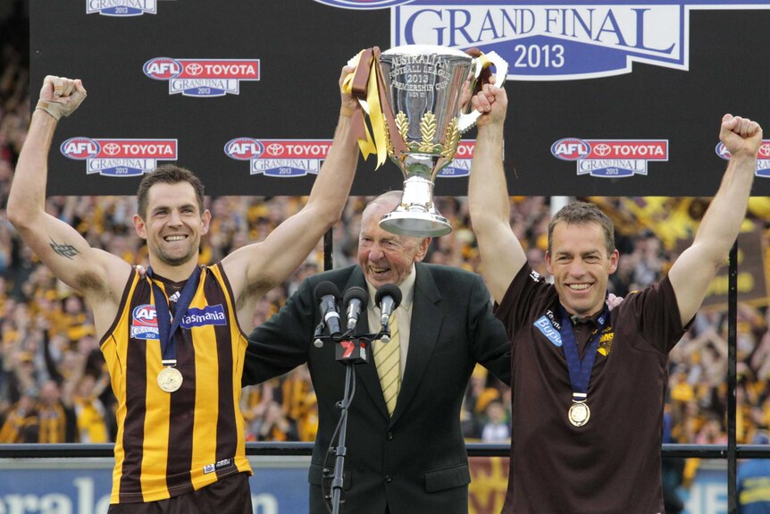 Hawthorn captain Luke Hodge and coach Alistair Clarkson receive the AFL premiership cup from John Kennedy.