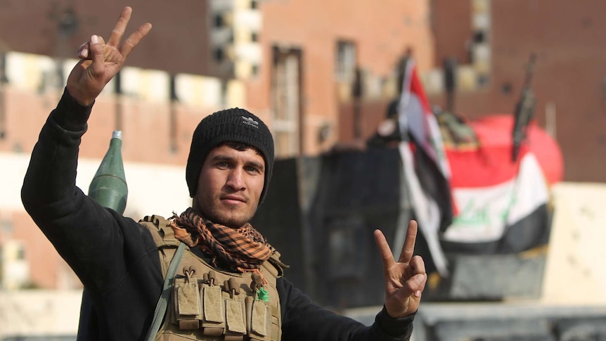Iraqi soldier signs "V" for victory