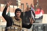 Iraqi soldier signs "V" for victory