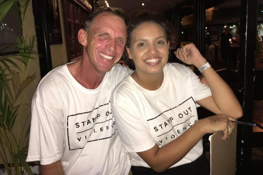 a group of people in t-shirts saying 'stamp out violence' at night
