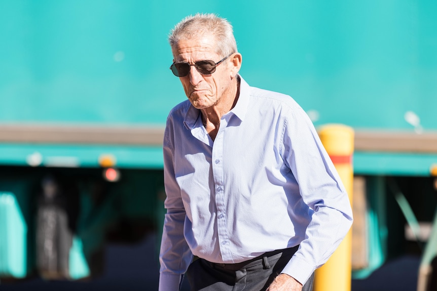 An elderly man walking into a court appearance.  