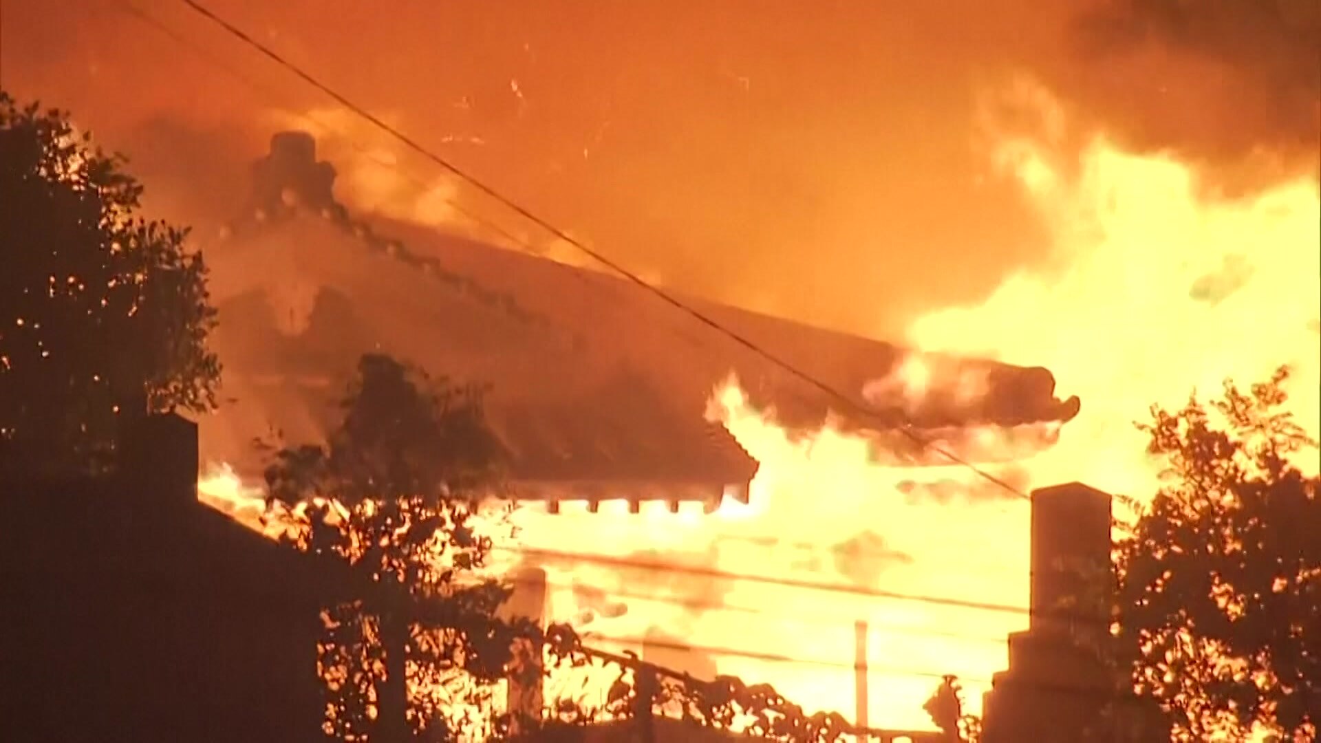 Flames engulf building with pagoda-style roof.