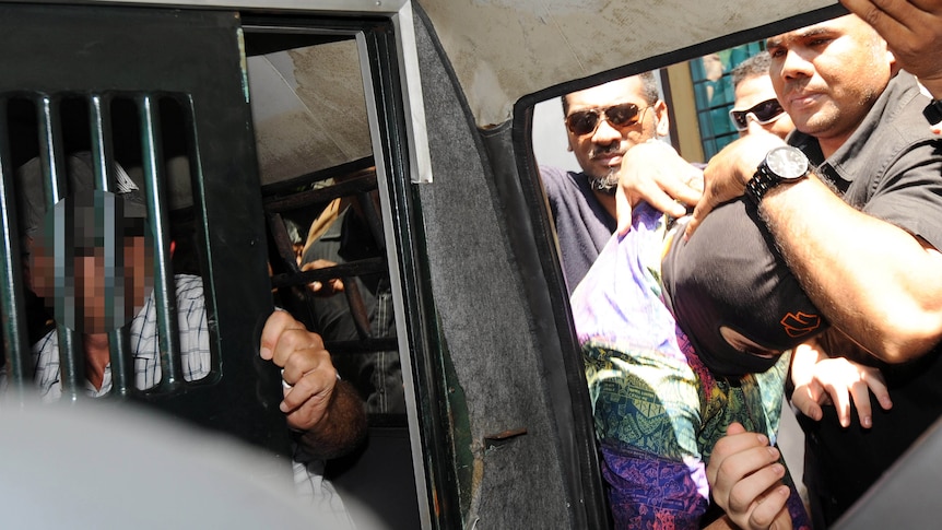 An Australian teenager (C) leaves Denpasar court