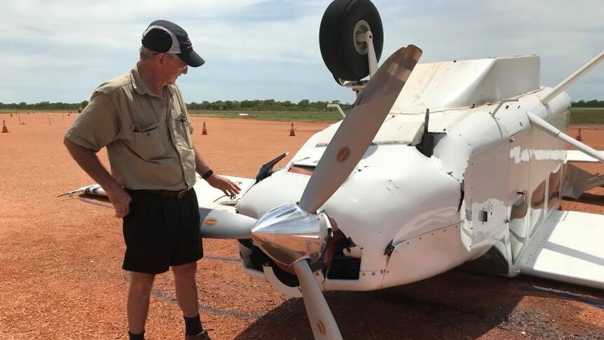 Rod Johnston looks at the upturned aircraft at the Derby Airport.