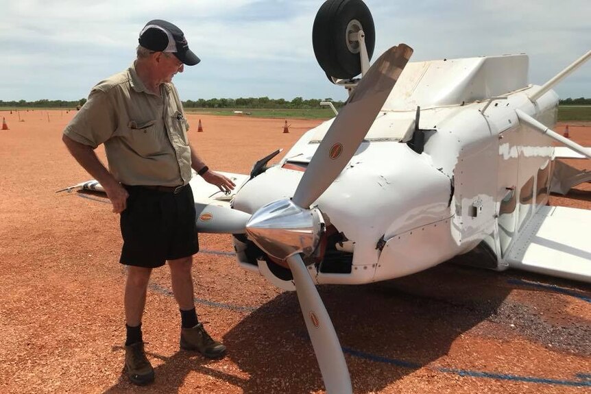 Rod Johnston looks at the upturned aircraft at the Derby Airport.
