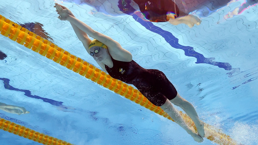 An underwater camera captures an Australian swimmer stretching out after her dive in the pool at the start of a race.