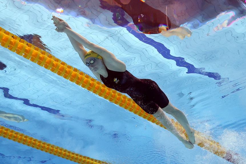 An underwater camera captures an Australian swimmer stretching out after her dive in the pool at the start of a race.