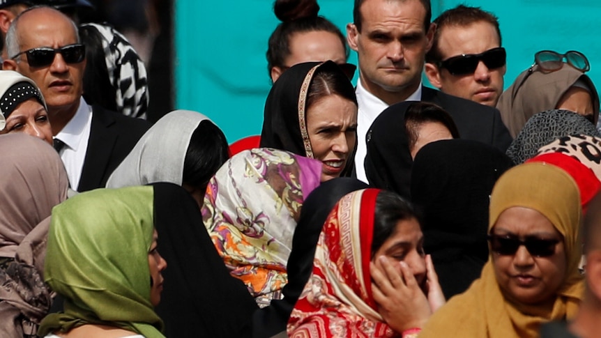 NZ PM Jacinda Ardern wears a headscarf among the crowd.