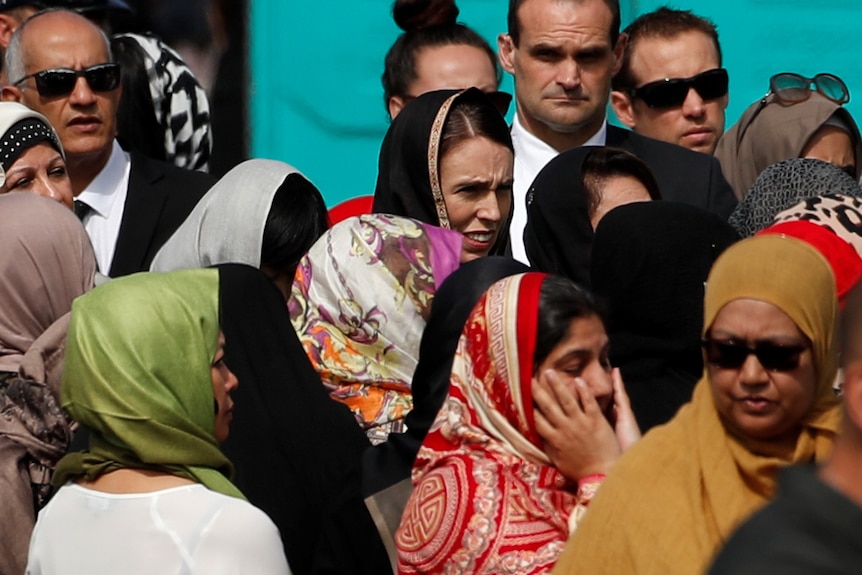 NZ PM Jacinda Ardern wears a headscarf among the crowd.